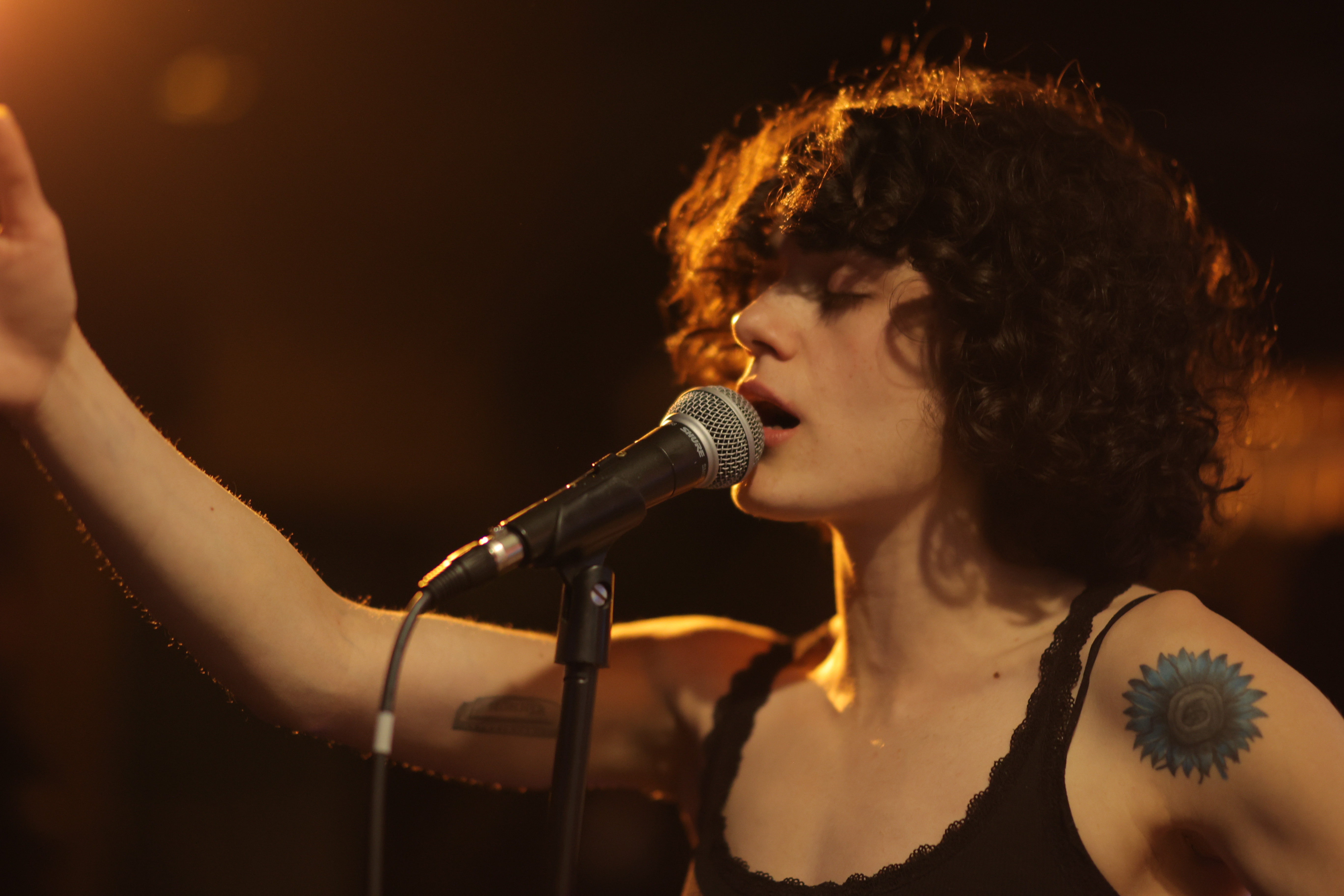 Kardelen Köksalan singing under warm stage lights
